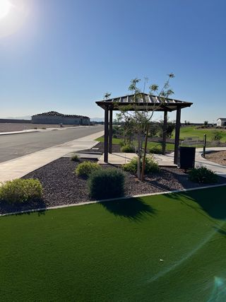 A peaceful street view with a pergola and manicured landscaping in The Retreat at Rancho Cabrillo by Scott Communities (Peoria, AZ).