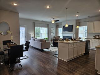 An open-layout kitchen and living area featuring modern fixtures, sleek flooring, and abundant natural light.