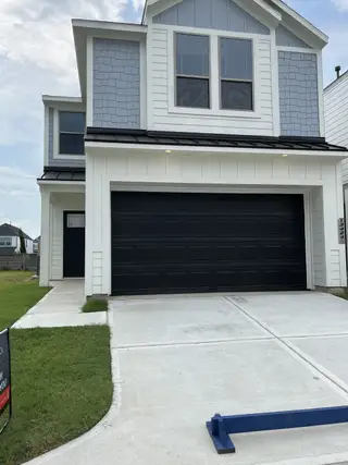 Modern two-story home with dark garage in Cay Landing by First America Homes (Houston, TX).