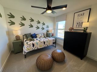 Model Home A playful dinosaur-themed bedroom with wall decals, cozy bedding, and modern decor accents.