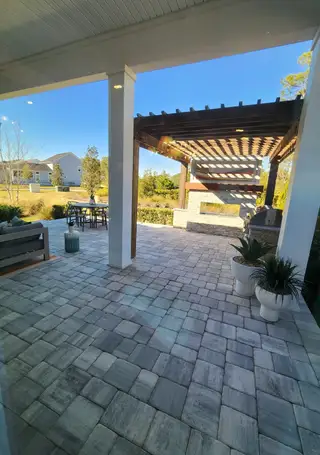 A serene outdoor living space with a pergola, built-in fireplace, and cozy seating, perfect for entertaining or relaxation.