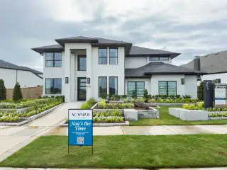 Street view A modern white brick home with lush landscaping in Grange 60' by Perry Homes (Katy, TX).