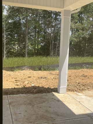 Model Home A serene backyard patio with a concrete floor and woods view, offering a peaceful outdoor retreat.