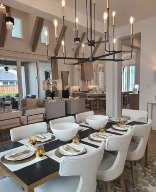 Model Home An elegant dining area with plush seating, decorative chandeliers, and a seamless transition to the cozy living space.