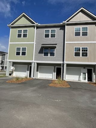 Modern townhomes with varied facades and garages in Bermuda Pointe Towns by Prosperity Builders (Charleston, SC).