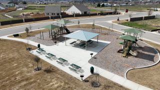 Community Amenities A modern playground with seating and shaded areas in Weltner Farms 50's by View Homes, New Braunfels, TX.
