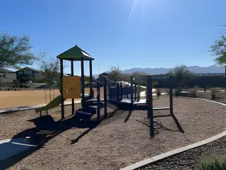 A charming playground with slides and climbing elements in Estrella Crossing by Starlight Homes (Laveen, AZ).
