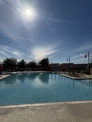 A refreshing community pool under a clear sky in Orchard Ridge by CastleRock Communities (Liberty Hill, TX).