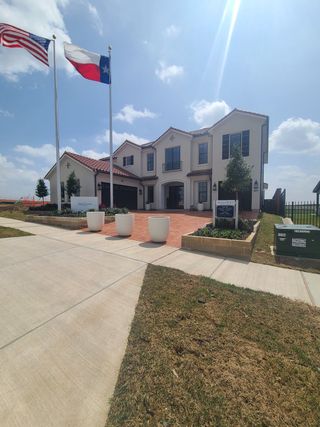 A beautiful two-story home with a red-tiled roof and landscaped entrance in Fields Reserve - 70's by Landon Homes (Frisco, TX).