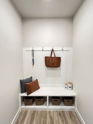 A cozy mudroom with hooks, a bench, storage baskets, and stylish cushions. Perfectly organized for modern living.