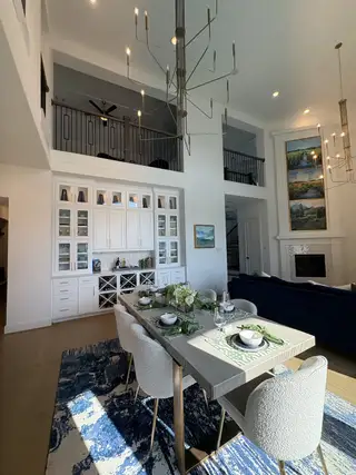 Model Home A spacious dining area with a modern chandelier, elegant table setting, built-in cabinetry, and natural light.