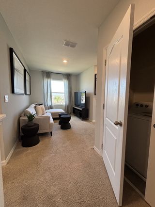 A spacious loft with neutral tones and contemporary furniture in Osceola Village Townhomes by D.R. Horton (Kissimmee, FL).