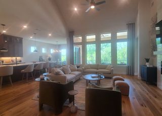 Model Home A spacious open-concept living area with large windows, plush seating, and elegant hardwood floors.