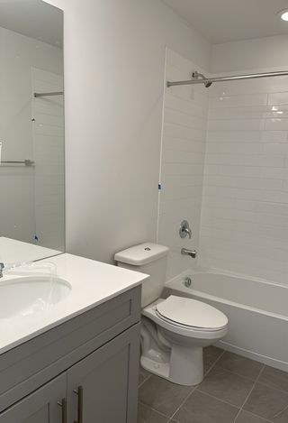 A stylish upstairs bathroom featuring a white subway-tiled shower, a modern vanity, and sleek hardware.