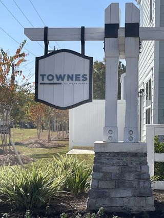 Street view Welcome to The Townes at Merrimack by D.R. Horton, featuring lush landscaping in Moncks Corner, SC.