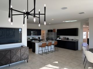 Model Home A sleek kitchen with black cabinetry, a center island, and modern lighting.