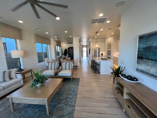 A modern, open-concept living area with elegant furnishings, natural light, and a sleek kitchen.