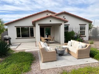 Charming bungalow with a cozy patio and lush garden in Dobbins Manor Traditions by KB Home, Phoenix, AZ.