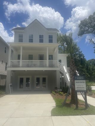 A charming white home with a spacious porch in Indigo Grove Single Family Homes by Stanley Martin Homes (Johns Island, SC).