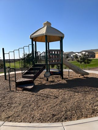 Charming community playground with a slide in The Retreat at Rancho Cabrillo by Scott Communities (Peoria, AZ).