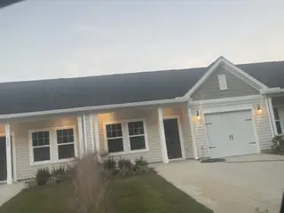 A charming single-story home with a tidy lawn in Hammock Walk at Nexton by Ashton Woods (Summerville, SC).