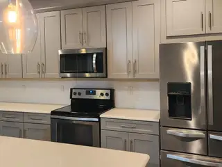 A modern kitchen with sleek gray cabinetry, stainless steel appliances, and subway tile backsplash in Copes Landing by D.R. Horton (Jacksonville, FL).