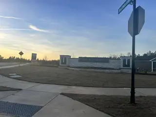 A welcoming entrance sign and landscaped lawn at Carolina Springs: Sterling Collection by Lennar in Apex, NC.