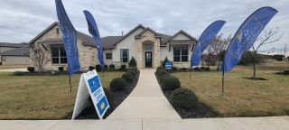 Street view Charming stone home with manicured landscaping in Annabelle Ranch by Bellaire Homes, San Antonio, TX.