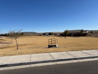 Expansive open field with distant homes under clear skies in Tortosa by KB Home, Maricopa, AZ.