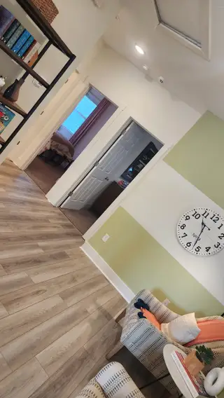 A vibrant loft area with light wood flooring, bold color-blocked walls, and a reading nook for relaxation