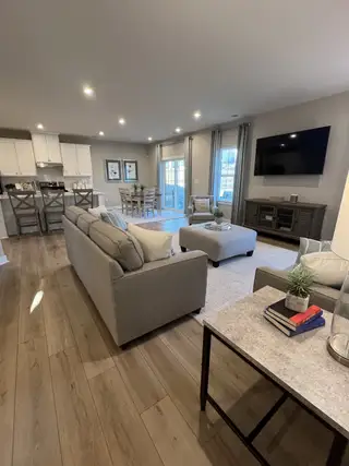 Model Home An inviting open living area with cozy gray seating, wooden floors, and modern decor.