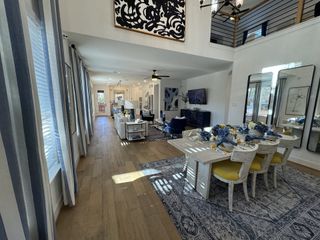 A spacious open-concept dining and living area with high ceilings, elegant decor, and natural light.