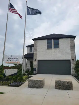 A contemporary brick home with a sleek driveway in Southridge by Trophy Signature Homes (McKinney, TX).