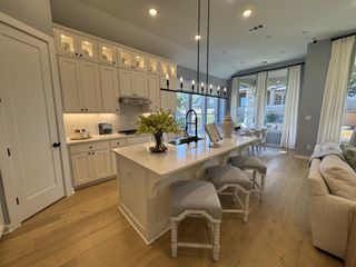 A stylish kitchen with light-colored cabinetry, modern fixtures, and an open layout leading to the dining area.