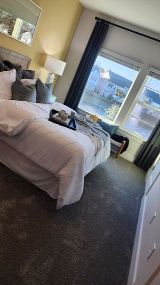 A luxurious bedroom with a plush bed, dark curtains, and scenic window views, blending comfort and sophistication.