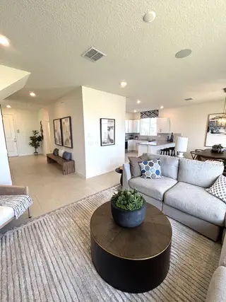 A cozy living area featuring a modern sofa, stylish coffee table, and open-plan layout with warm, inviting decor.
