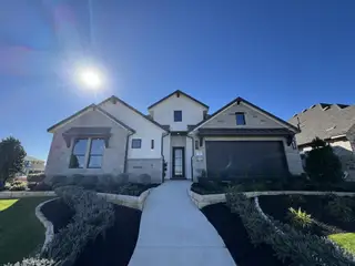 Model Home A modern stone facade home with manicured landscaping in Santa Rita Ranch by GFO Home (Liberty Hill, TX).