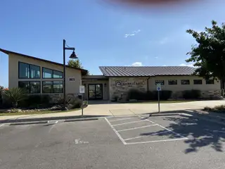 Community Amenities A vibrant community clubhouse with modern architecture and spacious parking in Saddle Creek Twinhomes by Pacesetter Homes (Georgetown, TX).