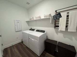 A modern laundry room featuring sleek appliances, stylish baskets, and practical shelving for efficient housework organization.