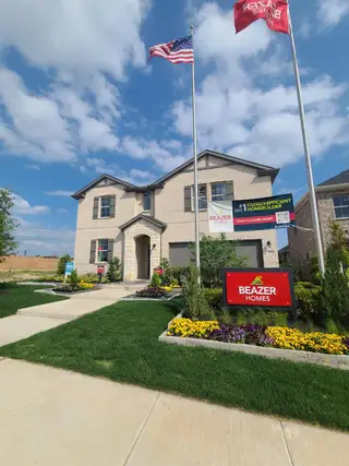 A beautiful brick home with lush landscaping in The Villages of Hurricane Creek: Meadows 50' by Beazer Homes (Anna, TX).