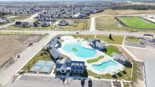 Community Amenities Aerial view of a vibrant community pool and tennis courts in Santa Rita Ranch by Westin Homes (Liberty Hill, TX).