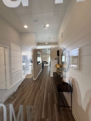 A modern hallway featuring wood flooring, sleek decor, and ambient lighting.