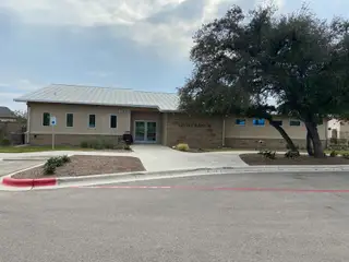 A modern community center with a metal roof and landscaped grounds at Lively Ranch: Claremont Collection by Lennar (Georgetown, TX).