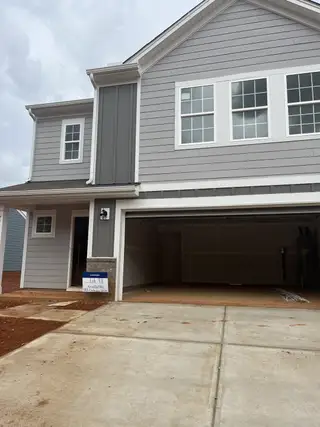 Street view A charming gray two-story home with a spacious garage in Sullivan Farm by Lennar (Statesville, NC).