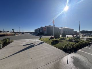 Sunny street view of modern homes with landscaped areas in Brentwood Townhomes by D.R. Horton, Davenport, FL.