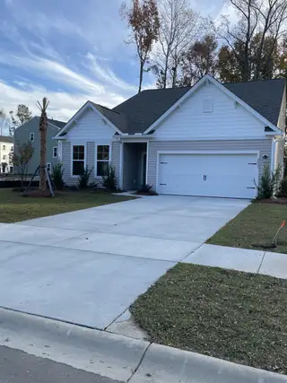 Street view A charming white siding home with a spacious driveway in Oak Pointe Single Family Homes by Stanley Martin Homes (Hanahan, SC).