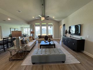 Model Home A spacious living room featuring elegant furniture, large windows, and open layout with contemporary decor and warm lighting.