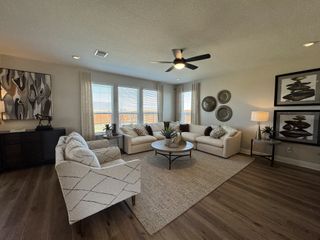 A modern living room with plush sofas, sleek decor, abstract art, and abundant natural light on wooden floors.