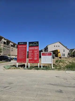 Street view New construction site with safety signage in Bayside by Beazer Homes, Rowlett, TX, showcasing ongoing residential development.