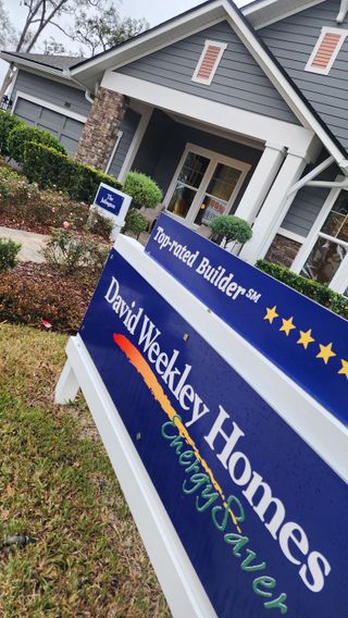 A beautifully designed home with a welcoming front porch and manicured lawn in Oak Grove at SilverLeaf by David Weekley Homes (St. Augustine, FL).